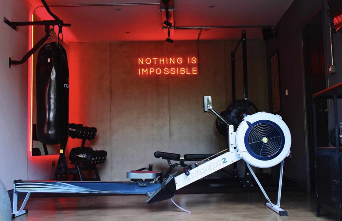 home gym with rowing machine and punchbag with LED lighting