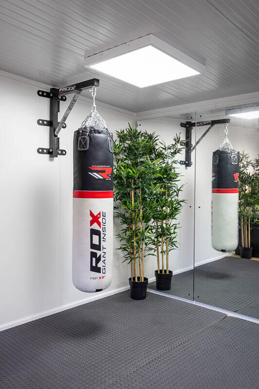 Hanging punch bag in garden gym with mirrored wall