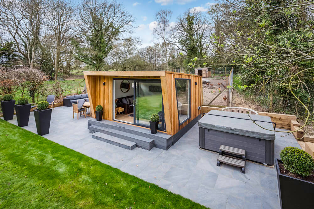 Garden room with a hot tub and garden furniture outside.