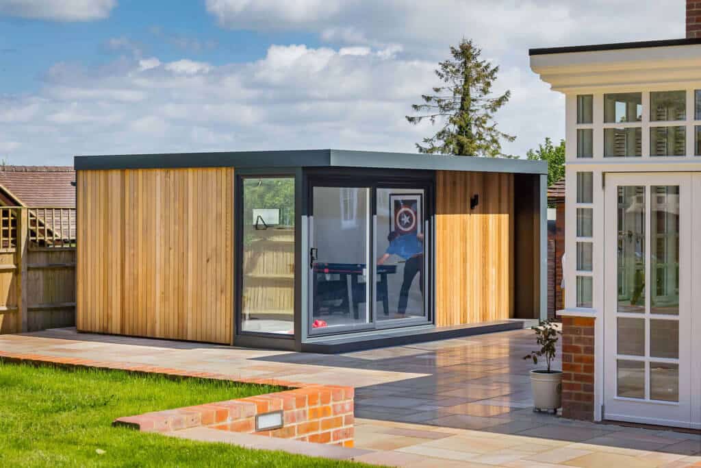 Outside view of garden games room clad with redwood and featuring graphite accents