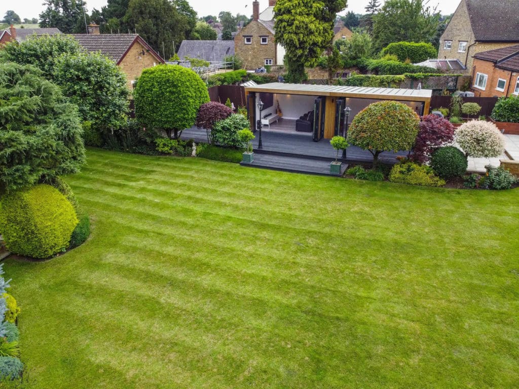 Exterior drone shot of a man cave in a landscaped garden