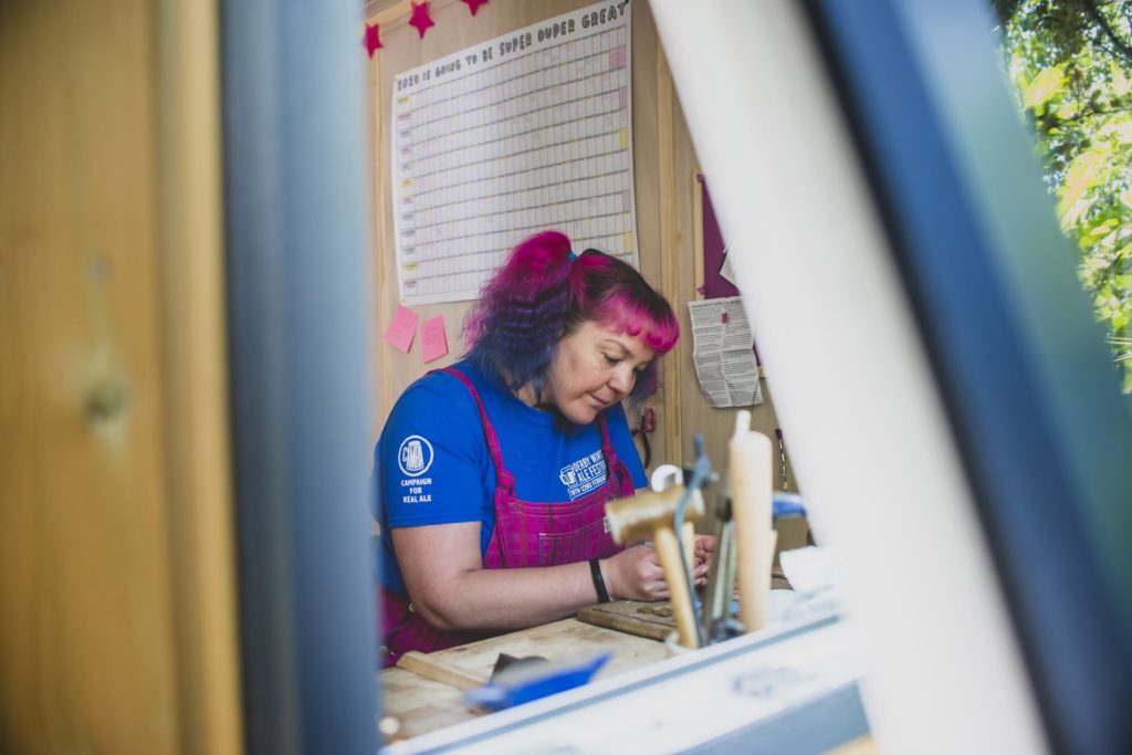 Close up on an open window of a home business, with our client working at her work bench.