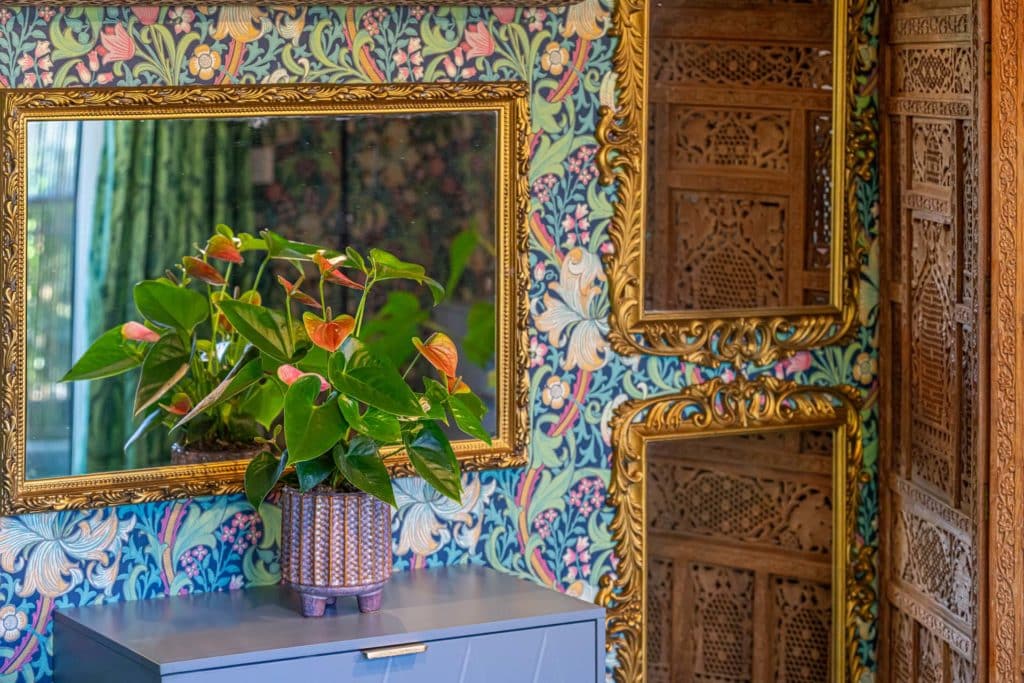 bold wallpaper with mirror and plant