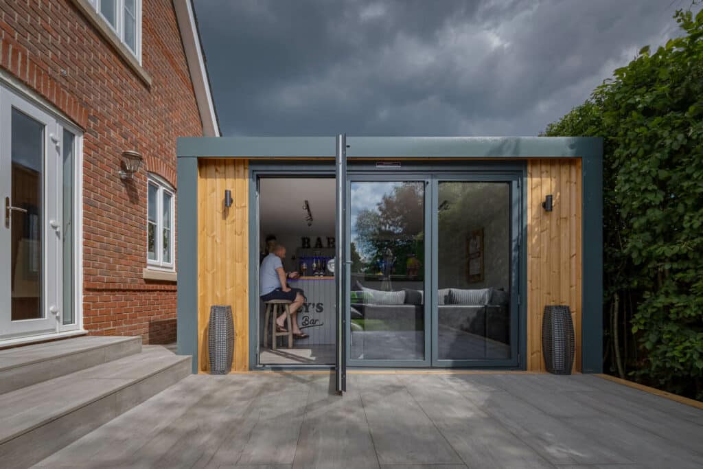 Exterior photo of Inspiration with bi-folds slightly open looking into man cave with a man on a bar stool