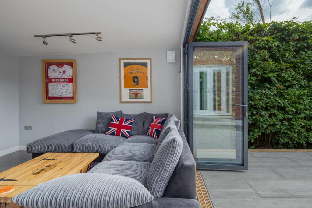 Interior of Inspiration man cave with bi-folds open and L shaped sofa with union jack cushions