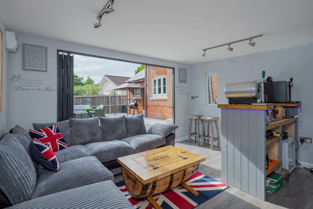 Interior of Inspiration man cave with grey L shaped sofa, coffee table and union jack rug