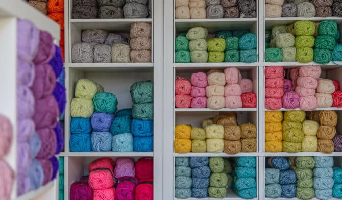 Home office being used as a yarn business with shelves of colourful yarn inside