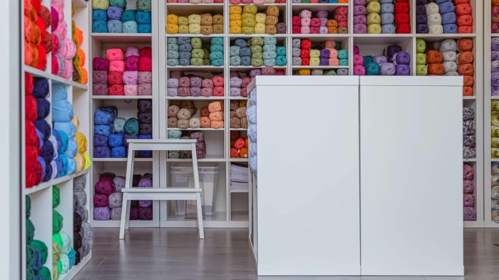 Home office being used as a yarn business with shelves of colourful yarn inside
