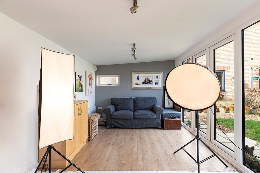 Green Retreats garden studio interior with photography lighting & a sofa
