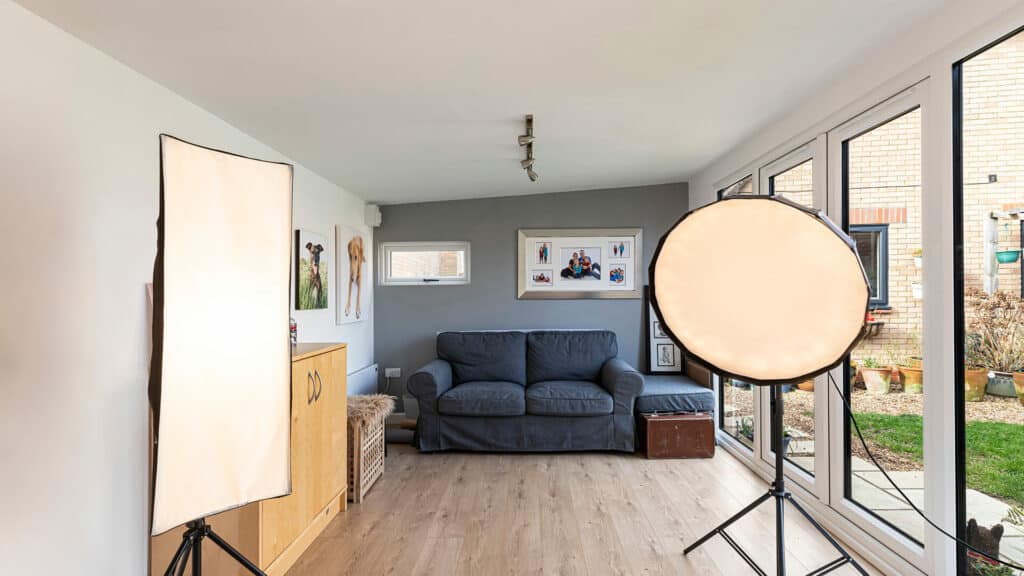 Interior of Inspiration photography studio with spotlights and a grey sofa on the back wall
