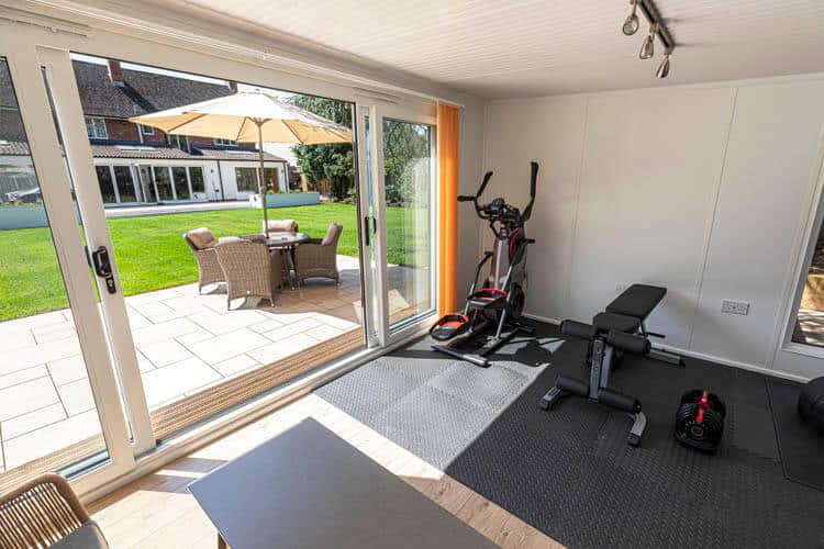 Section of the interior of a garden room with gym equipment