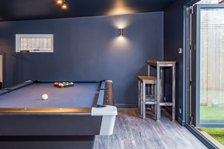 8ft pool table in family game room in garden room with dark blue walls