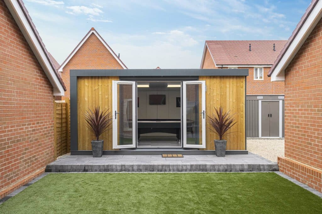 garden room is the focus point with patio and grass in view