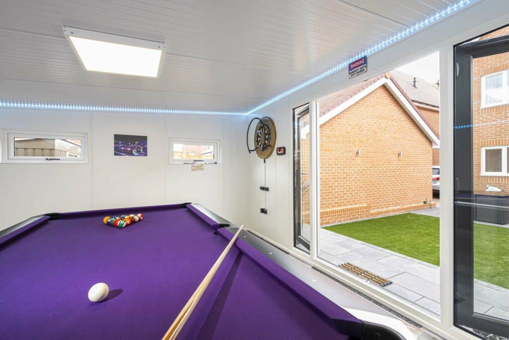 view of the pool table and doors of the garden room are open