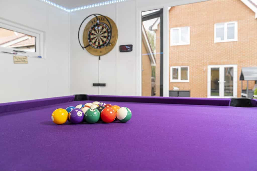 pool table is showing as the focus point with the house in the background