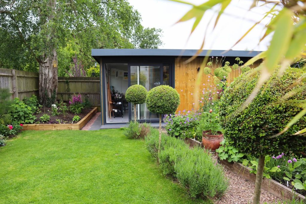 Half shot of garden room showing lolly pop trees and grass surroundings
