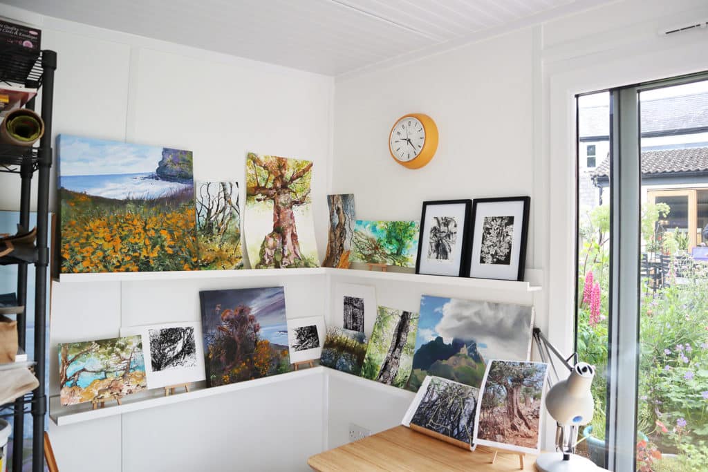 Inside garden room art studio of paintings on a shelf