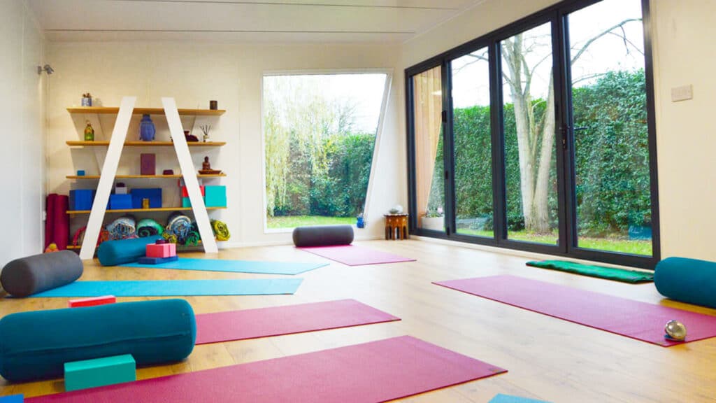 Interior of Pinnacle garden room used as a yoga studio with colourful yoga mats on the floor