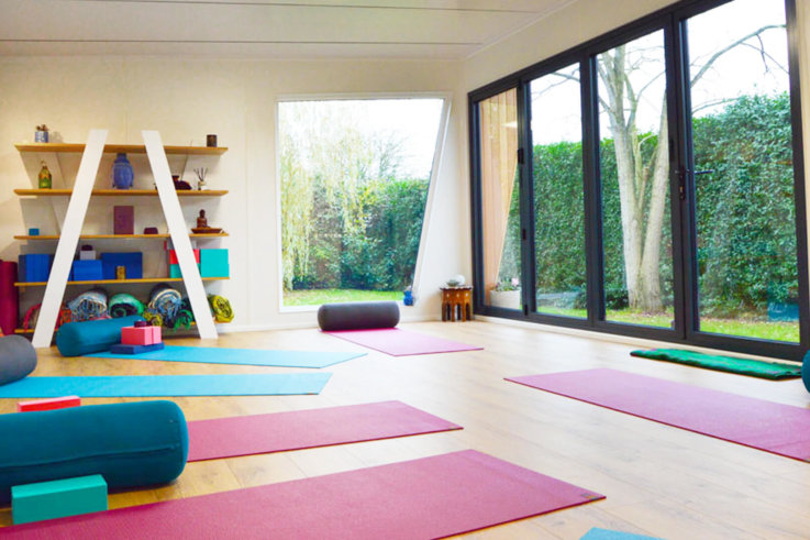 Interior of Pinnacle garden room used as a yoga studio with colourful yoga mats on the floor