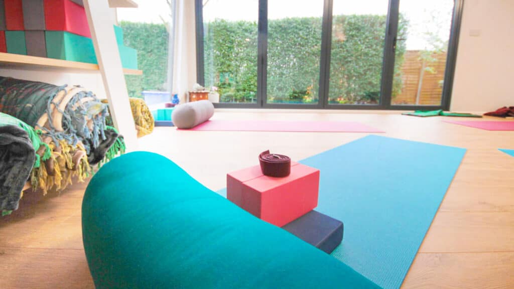 Interior of Pinnacle garden room used as a yoga studio with a pink yoga mat on the floor