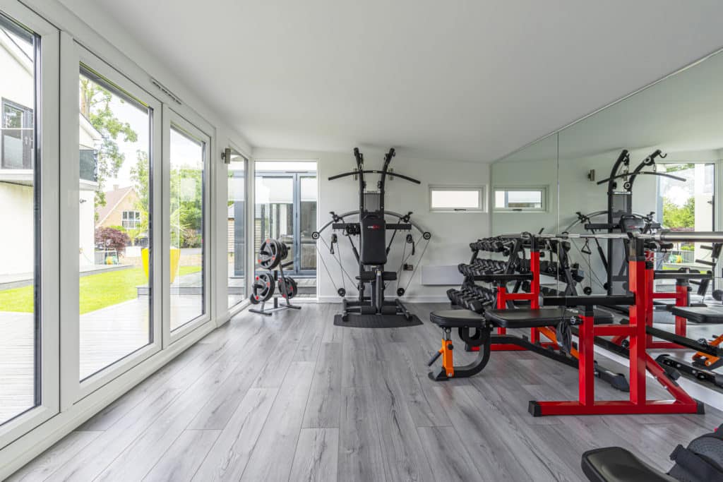 Garden room gym interior with weights and machines