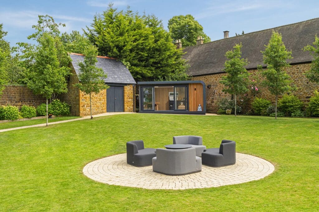 Garden seating area with garden room in the background