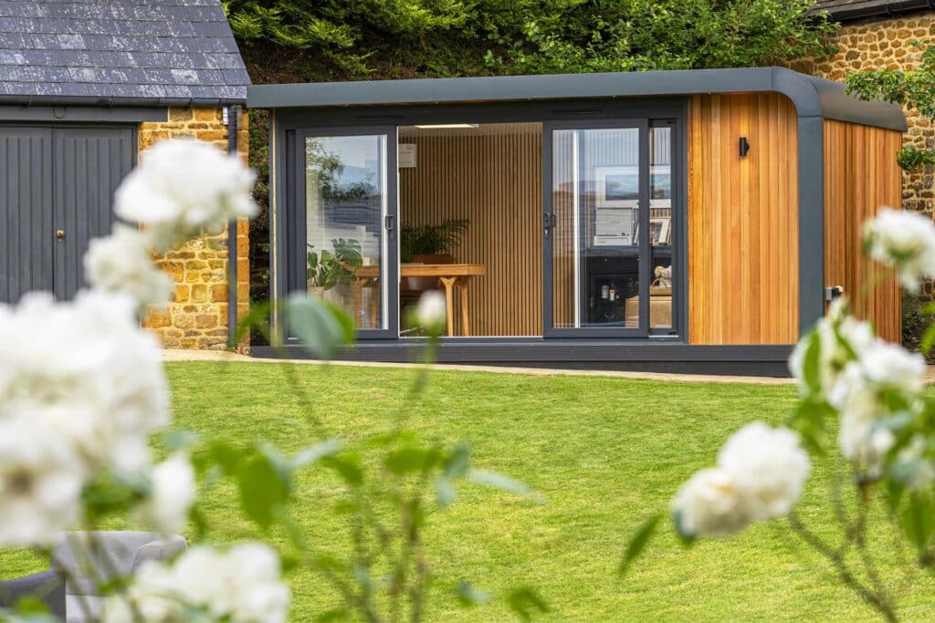 Garden room with sliding doors open being used as an office and lounge