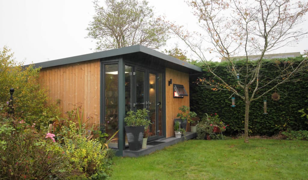 Outside view of garden writing office for author with wooden cladding