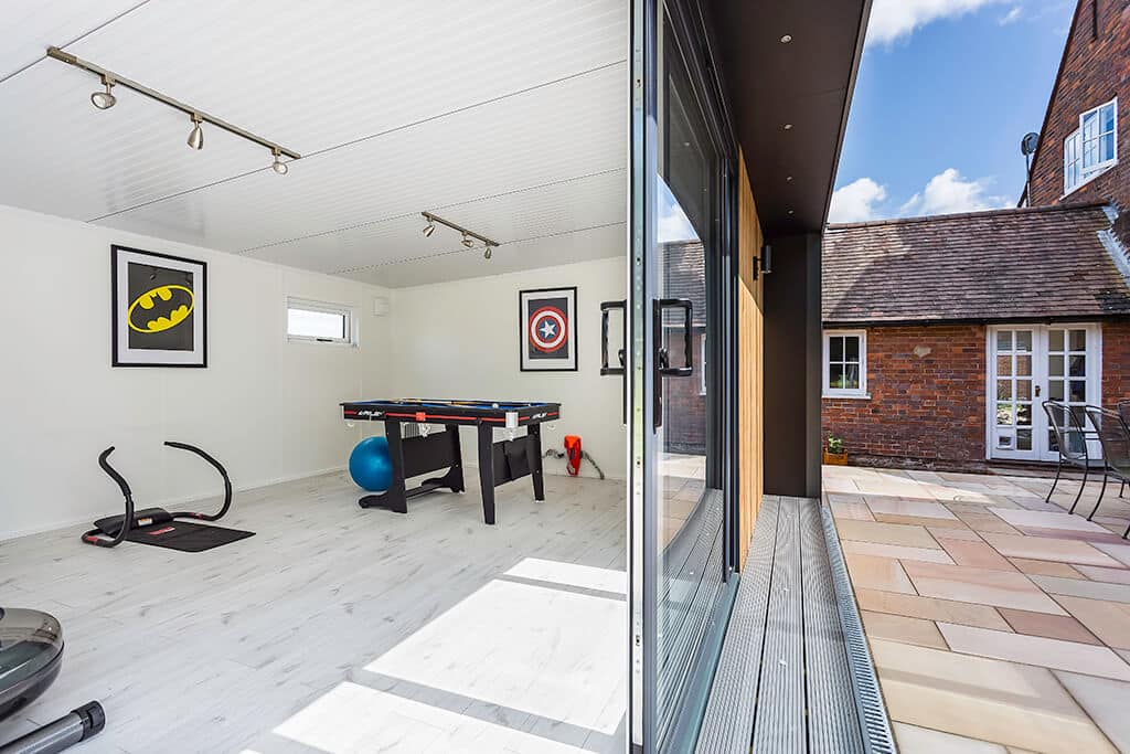 Joint interior and exterior view of garden games room with light oak flooring and pool table