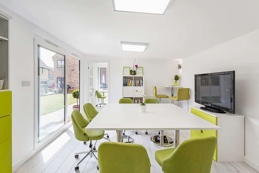 White and lime green meeting room decor in large garden office