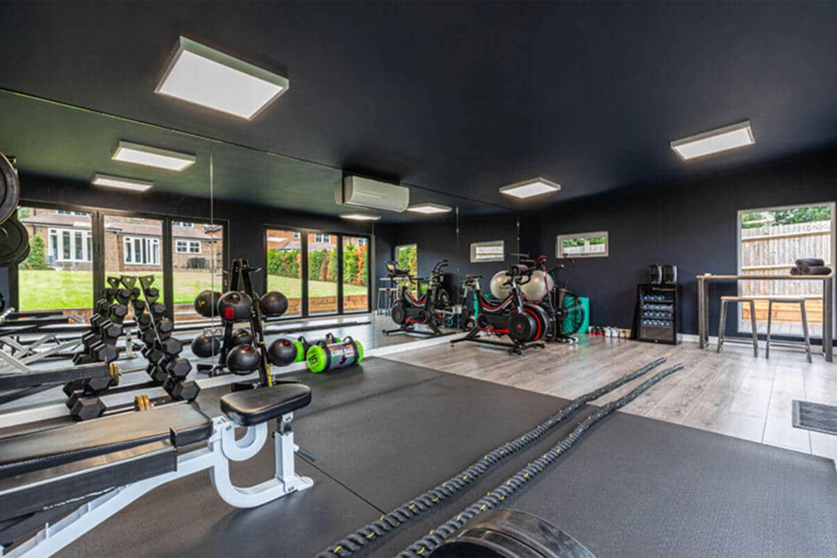 Green Retreats garden gym with gym equipment & a mirrored wall