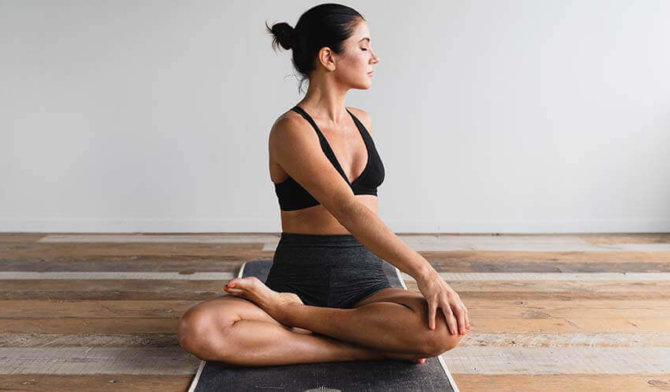 woman with legs crossed on mat